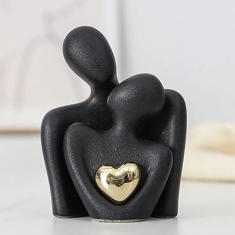 Black ceramic Couple Embrace figurine with gold heart accent, close-up