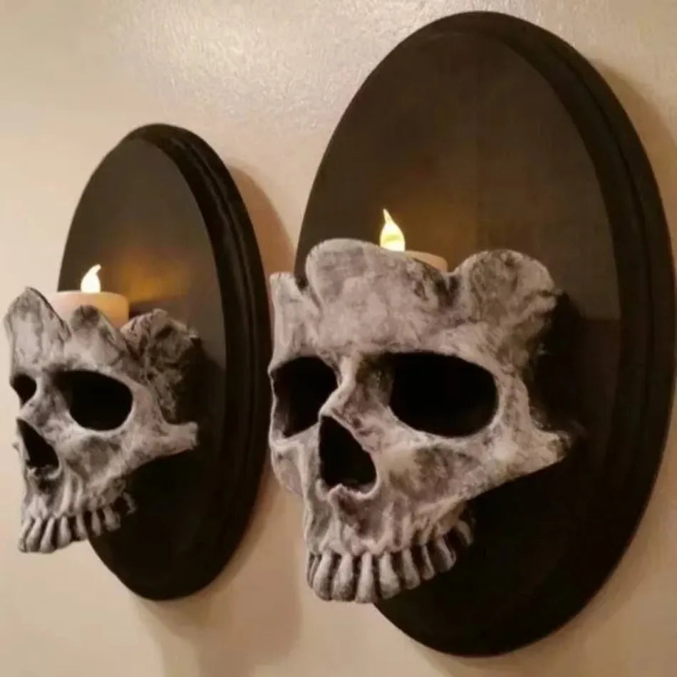 Gothic skull wall candle sconce in weathered stone-grey resin, two sizes shown mounted side by side