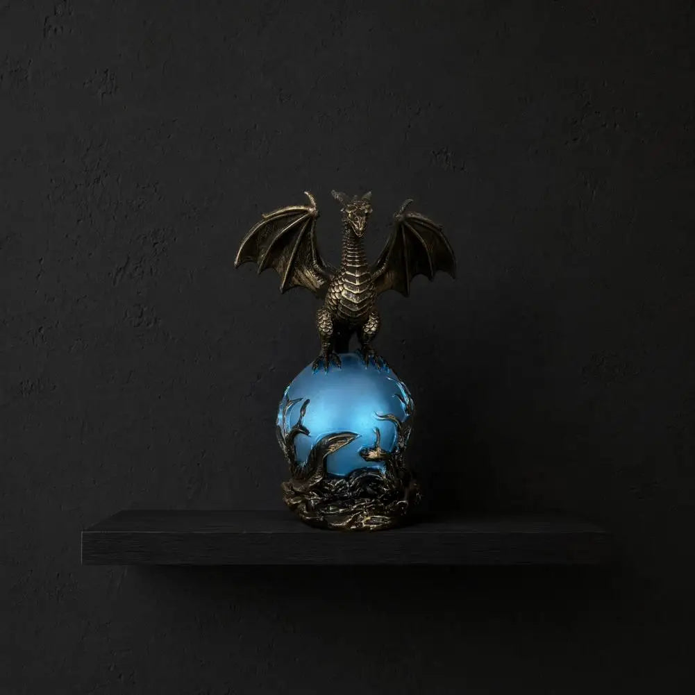 Dragon orb lamp glowing blue on a black shelf against a dark background