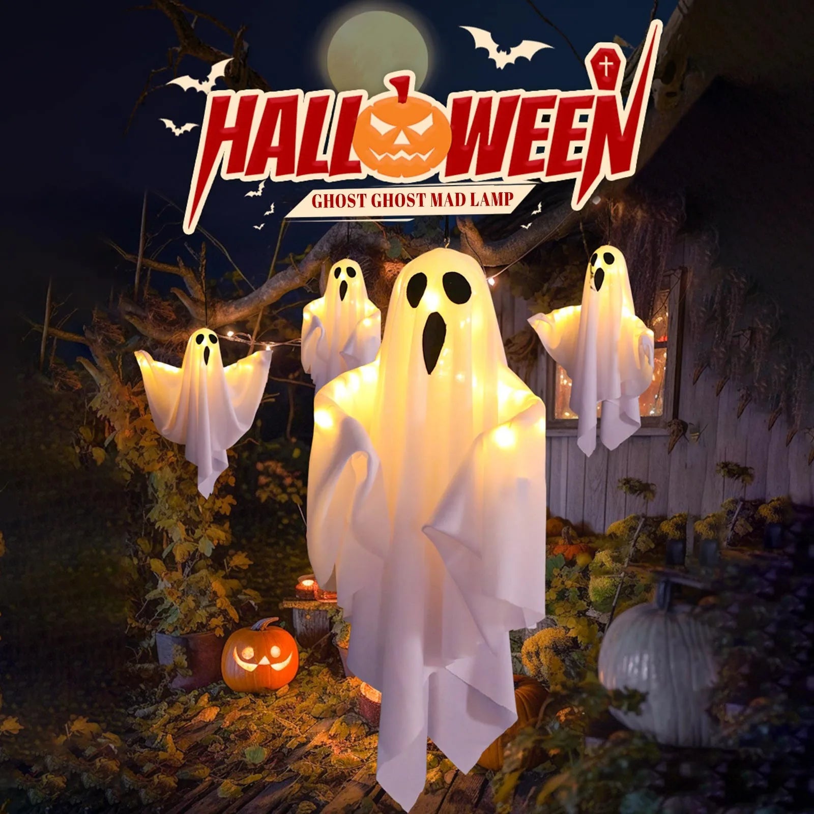 White and glowing fabric ghosts hanging from a tree with a Halloween decoration text banner