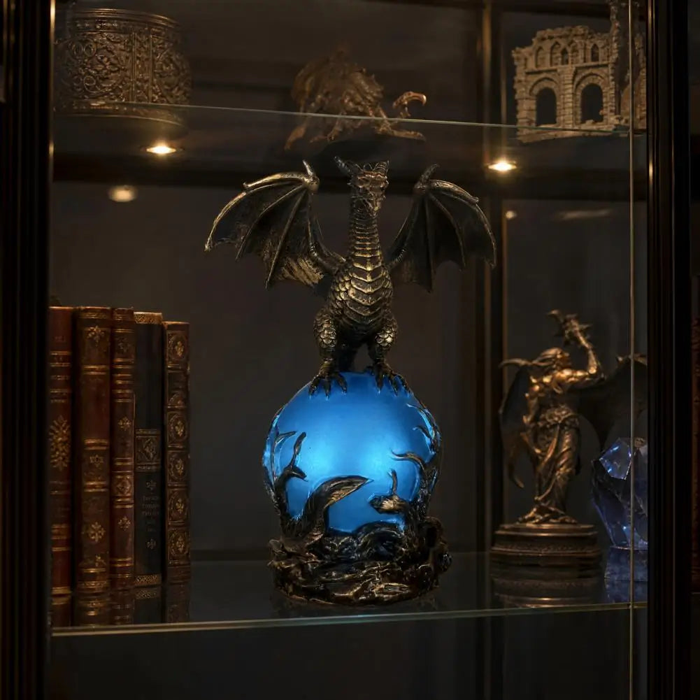 Dragon orb lamp glowing blue displayed in a curio cabinet with books and figurines