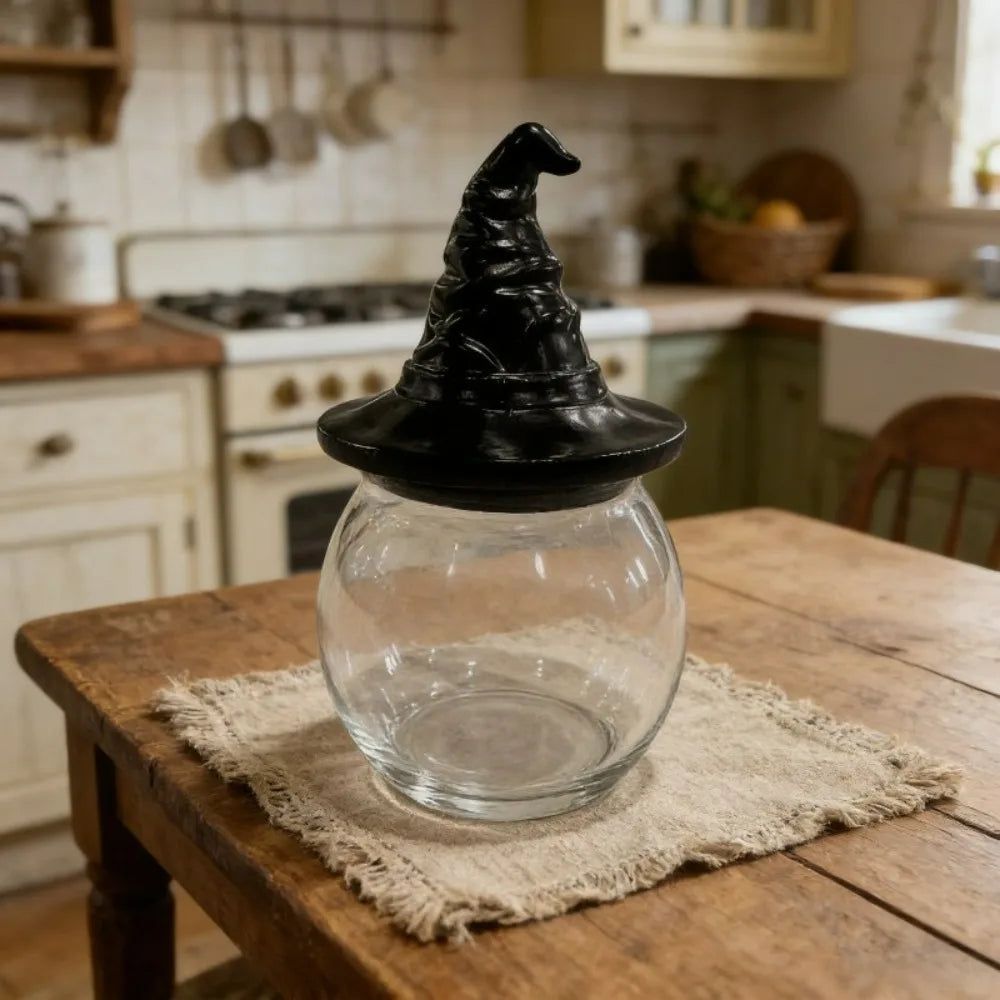 Single glass jar with a black witch hat lid on a rustic wooden table